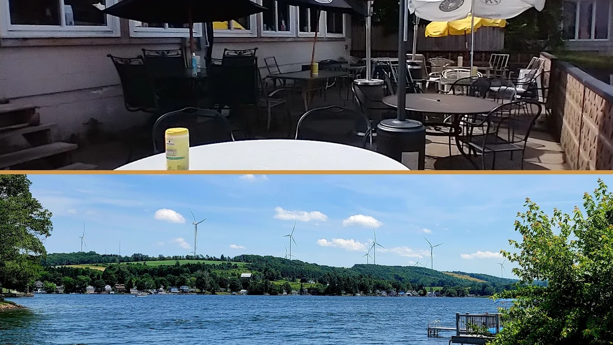 Patio seating beside a scenic waterfront.
