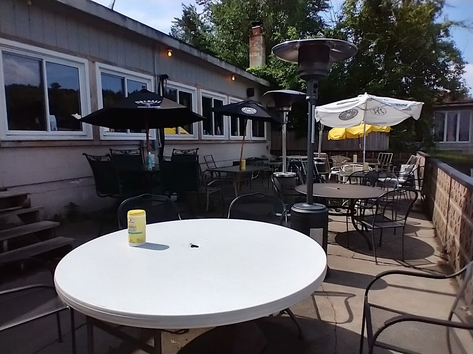 Patio seating beside a scenic waterfront.